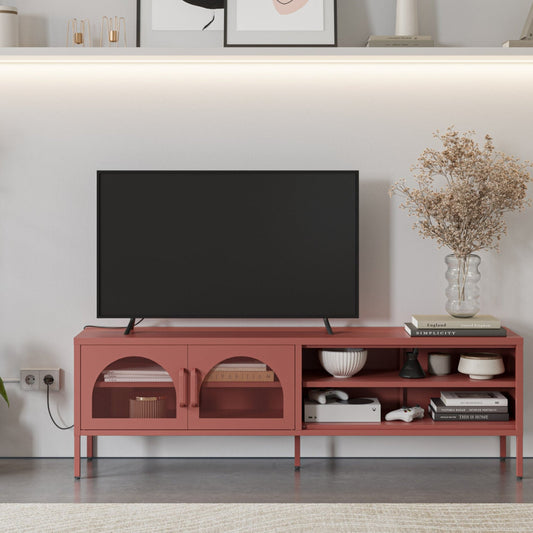 A modern terracotta red TV stand console in a living room setting, styled with a black flat-screen TV, books, bowls, and a vase of dried flowers against a white wall.