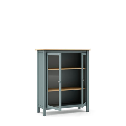 A tall kitchen cabinet with a muted blue-gray painted frame, a light natural wood top and shelves, and dark glass doors, shown on a plain white background.