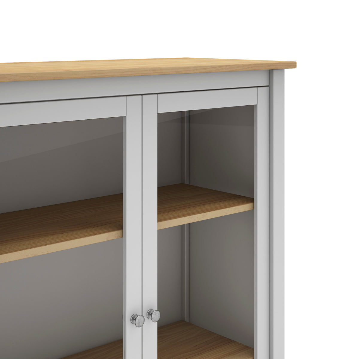 A close-up of a white storage cabinet with light wood grain shelves and a matching wood top, featuring two glass-front doors with silver knobs.