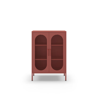A small two-door cabinet in a muted terracotta red color, featuring arched glass doors and two interior shelves, shown against a plain white background.