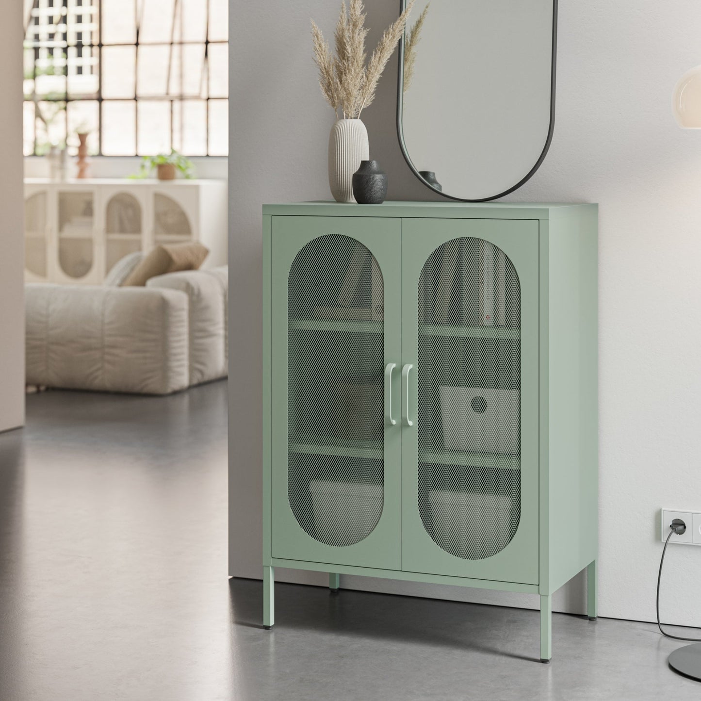 A mint green two-door cabinet with arched glass doors and metal handles, styled in a modern living room setting.