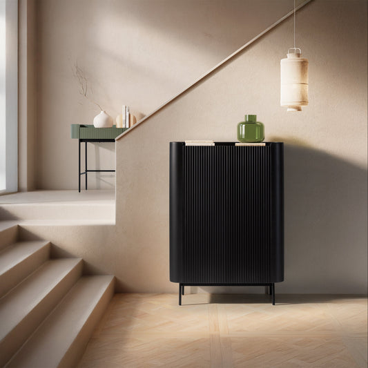 Modern black cabinet against a neutral wall with a staircase in the background