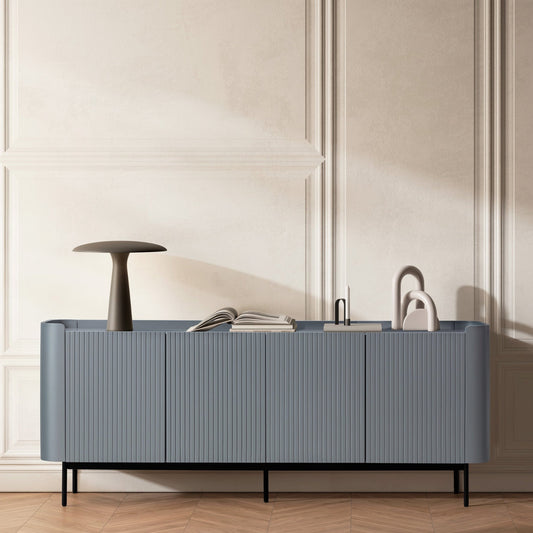 Modern bathroom vanity with blue cabinet, white sink, and black faucet against a beige paneled wall.