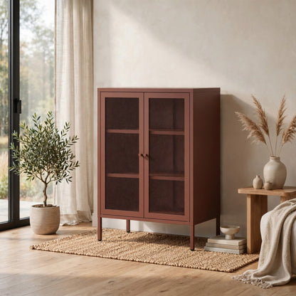A tall wooden cabinet with two dark glass-paneled doors stands in a styled room with a woven rug, potted plant, side table, and neutral decor.