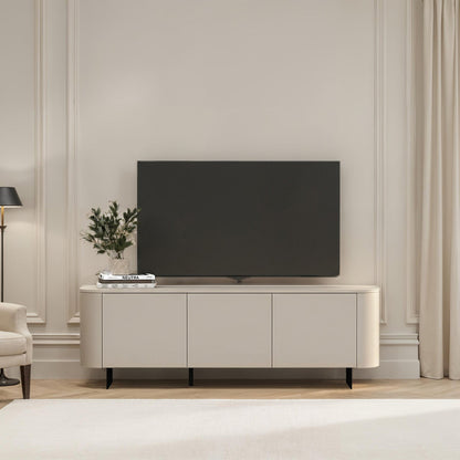 Modern living room with a television on a white cabinet, light-colored walls, and a window with curtains.