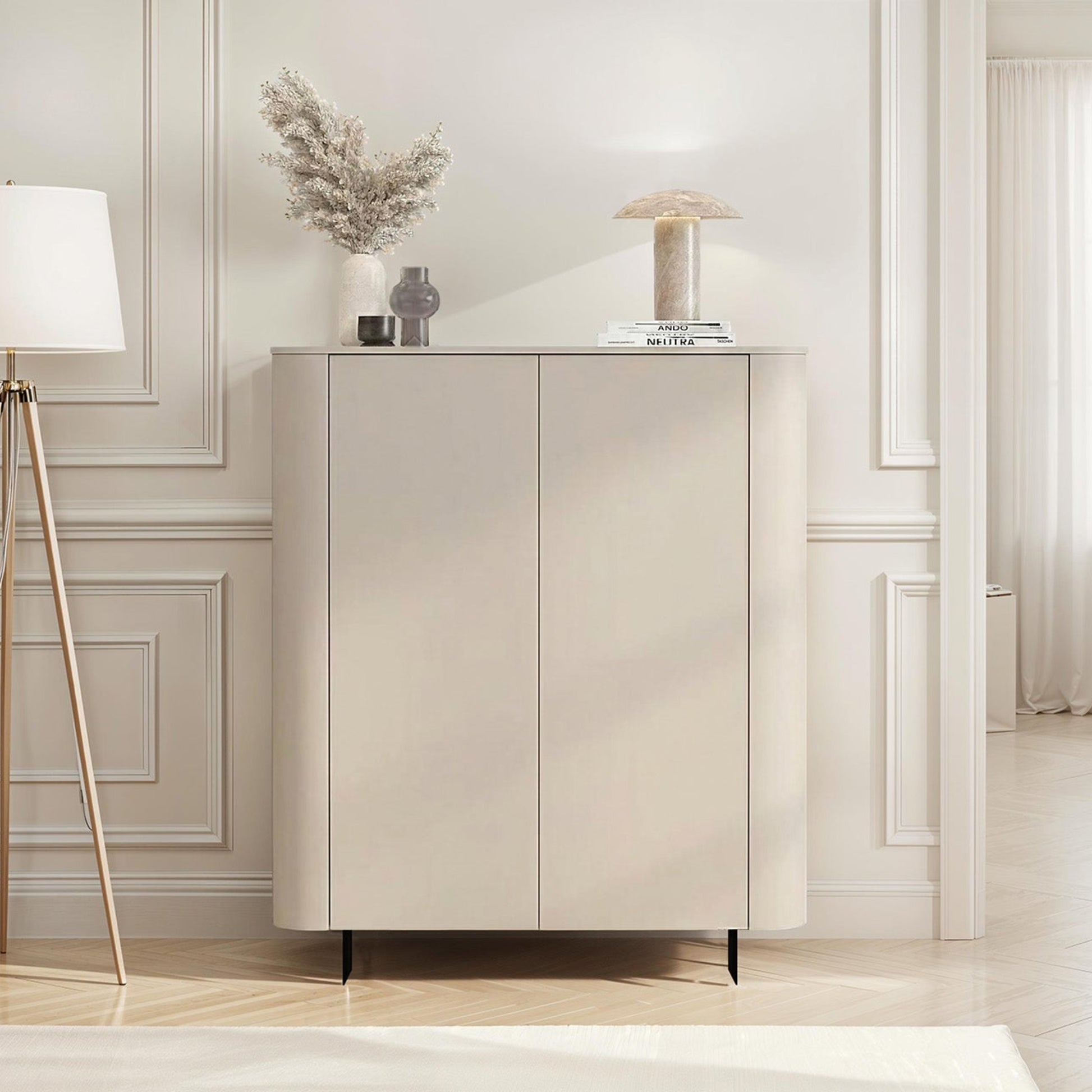 Modern interior with a light-colored cabinet, lamp, and chair in a room with white walls and wooden floor.