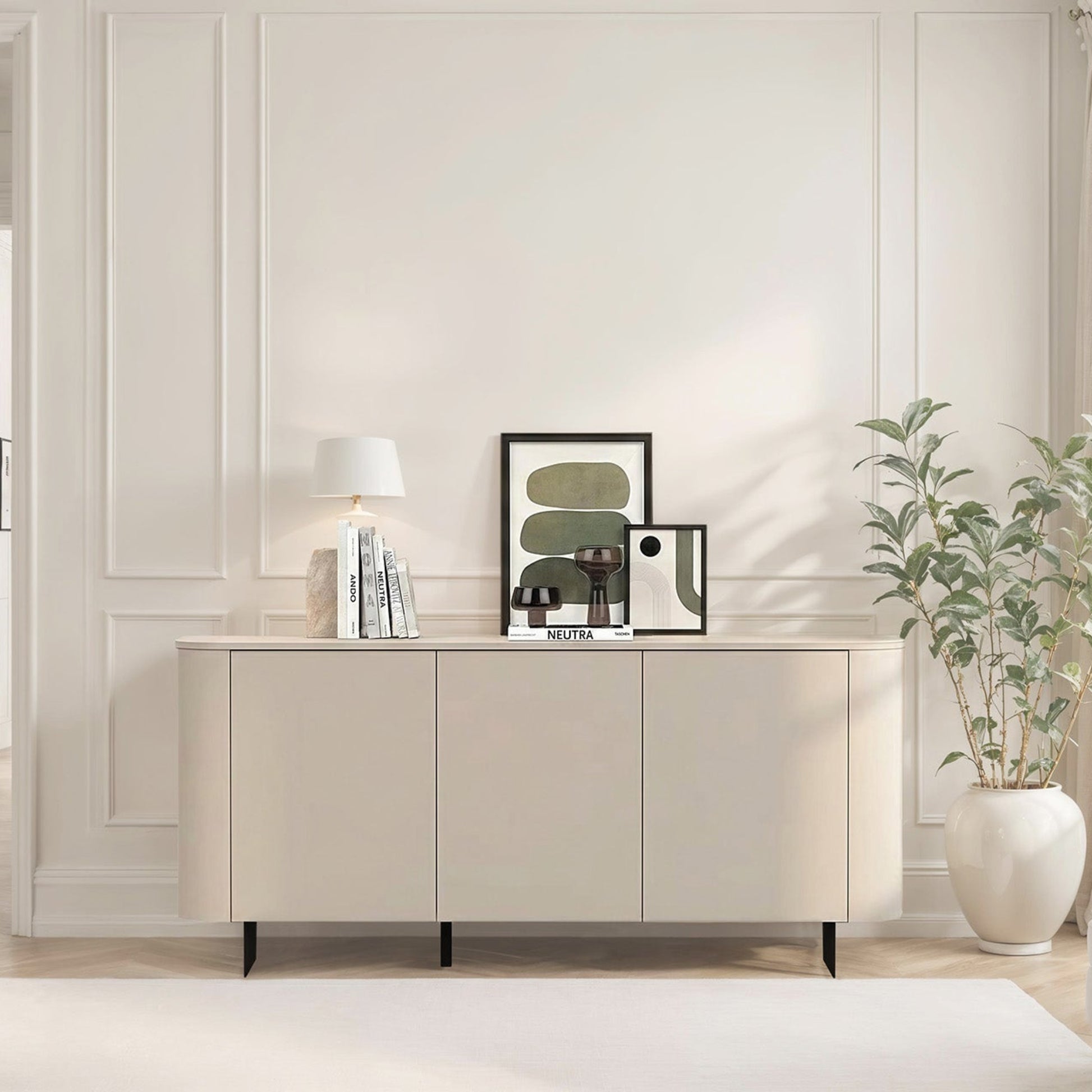 Modern living room with a sideboard, plant, and chair.