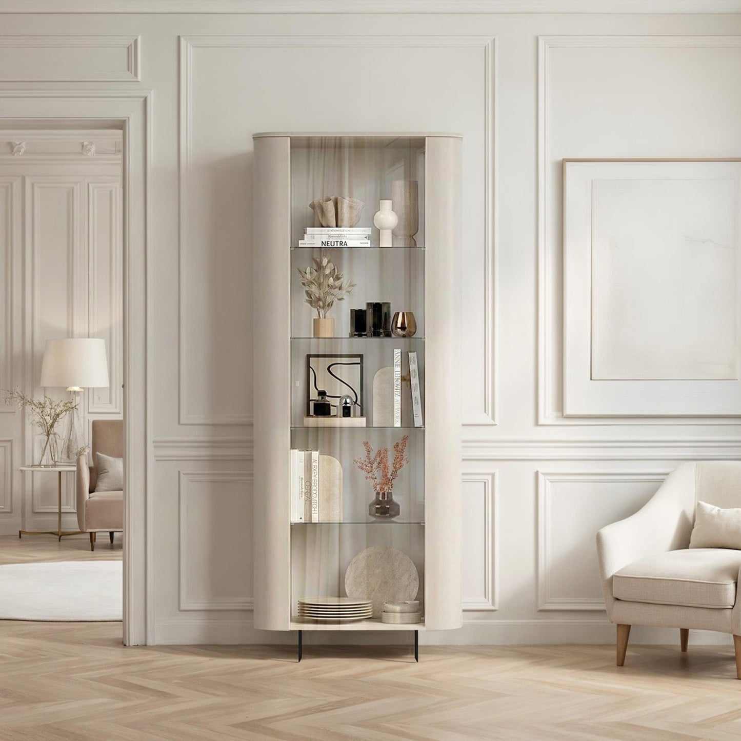 Modern living room with a white armchair, bookshelf, and decorative items.