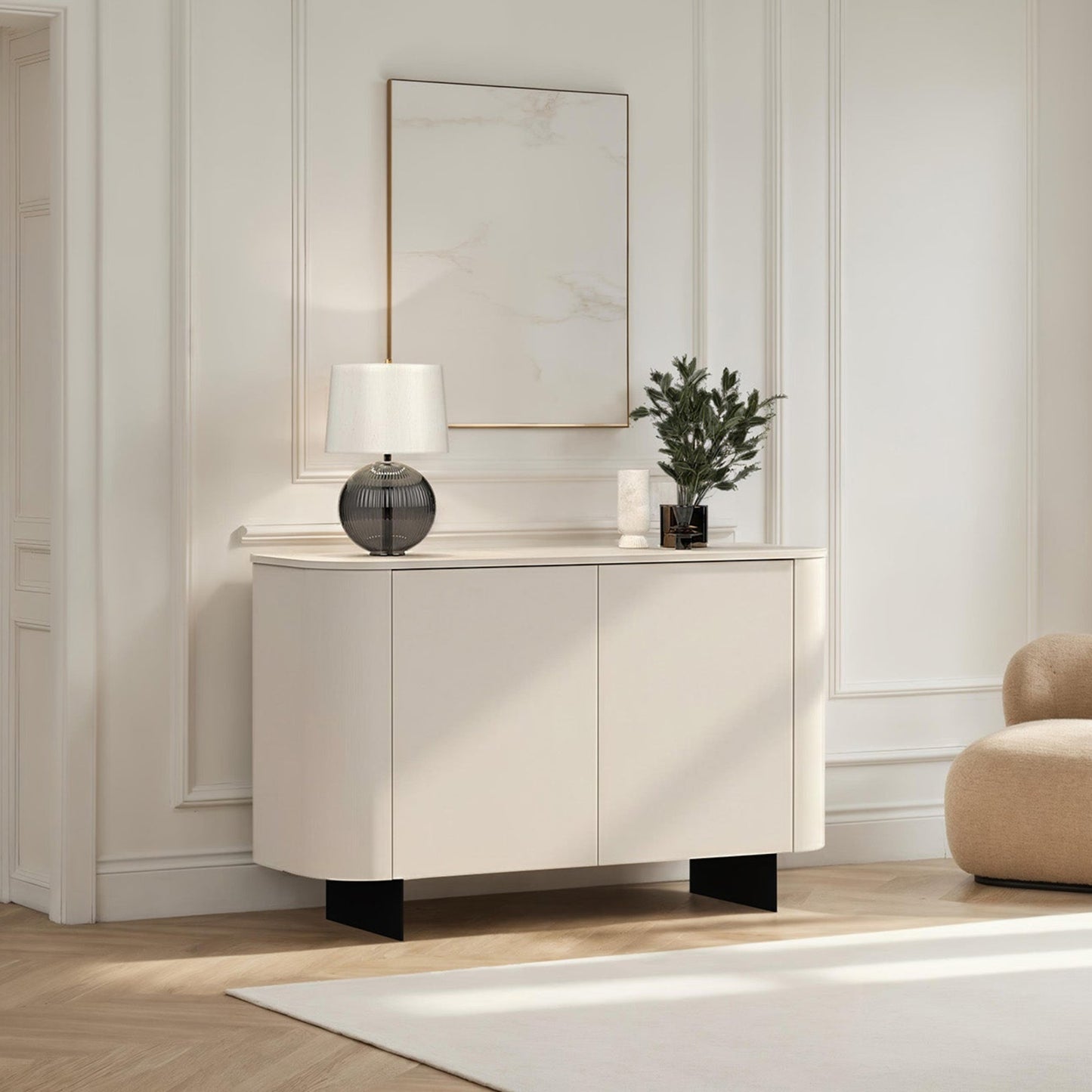 Modern interior with a white cabinet, beige armchair, and decorative items.
