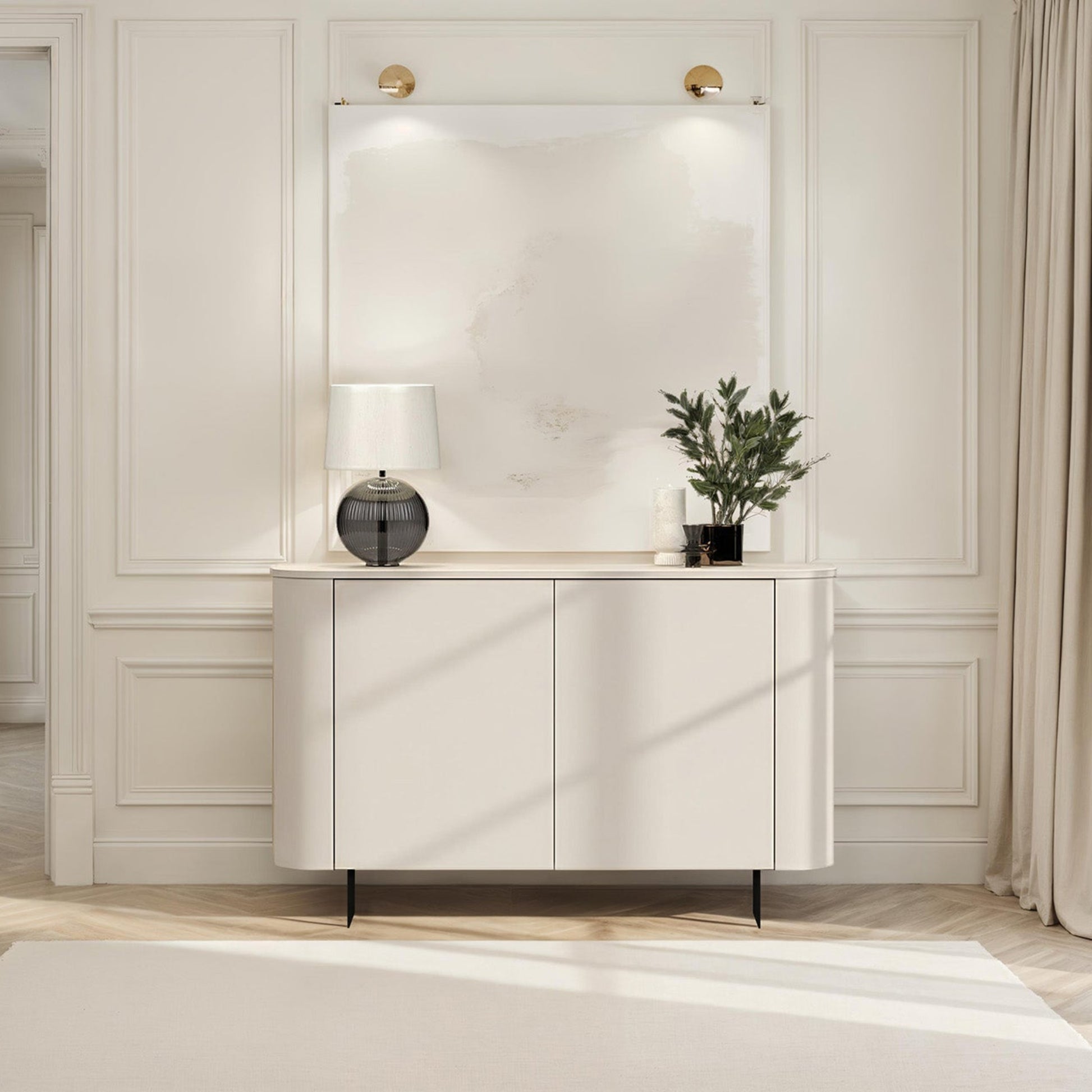Modern interior with a white console table, lamp, and plant against a neutral wall.