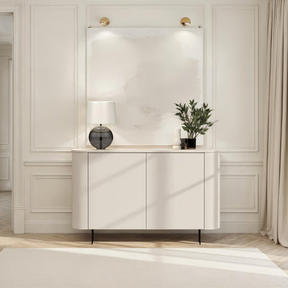 Modern interior with a white console table, lamp, and plant against a neutral wall.