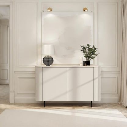 Modern interior with a white console table, lamp, and plant against a neutral wall.