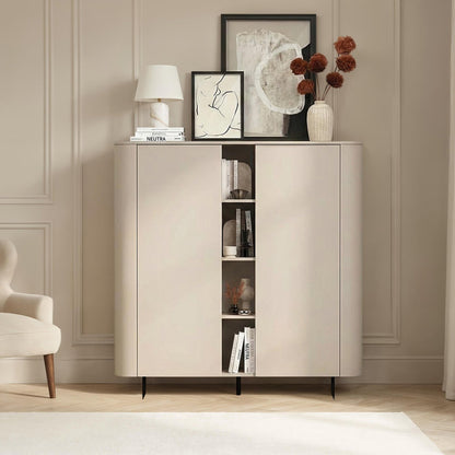 Beige sideboard with books and decor items in a room with a chair and lamp.