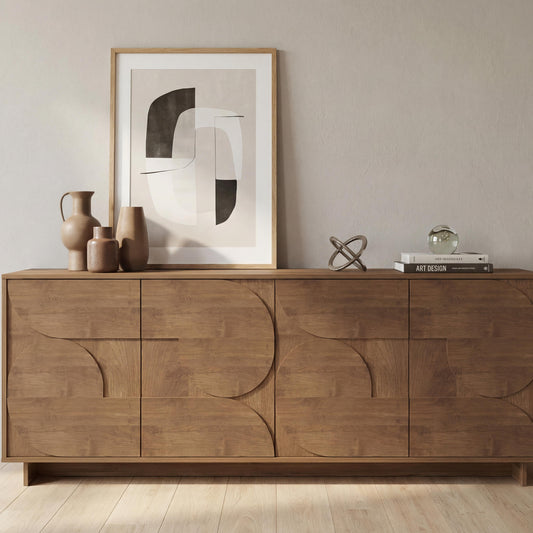 Wooden sideboard with abstract art and decorative items in a room.