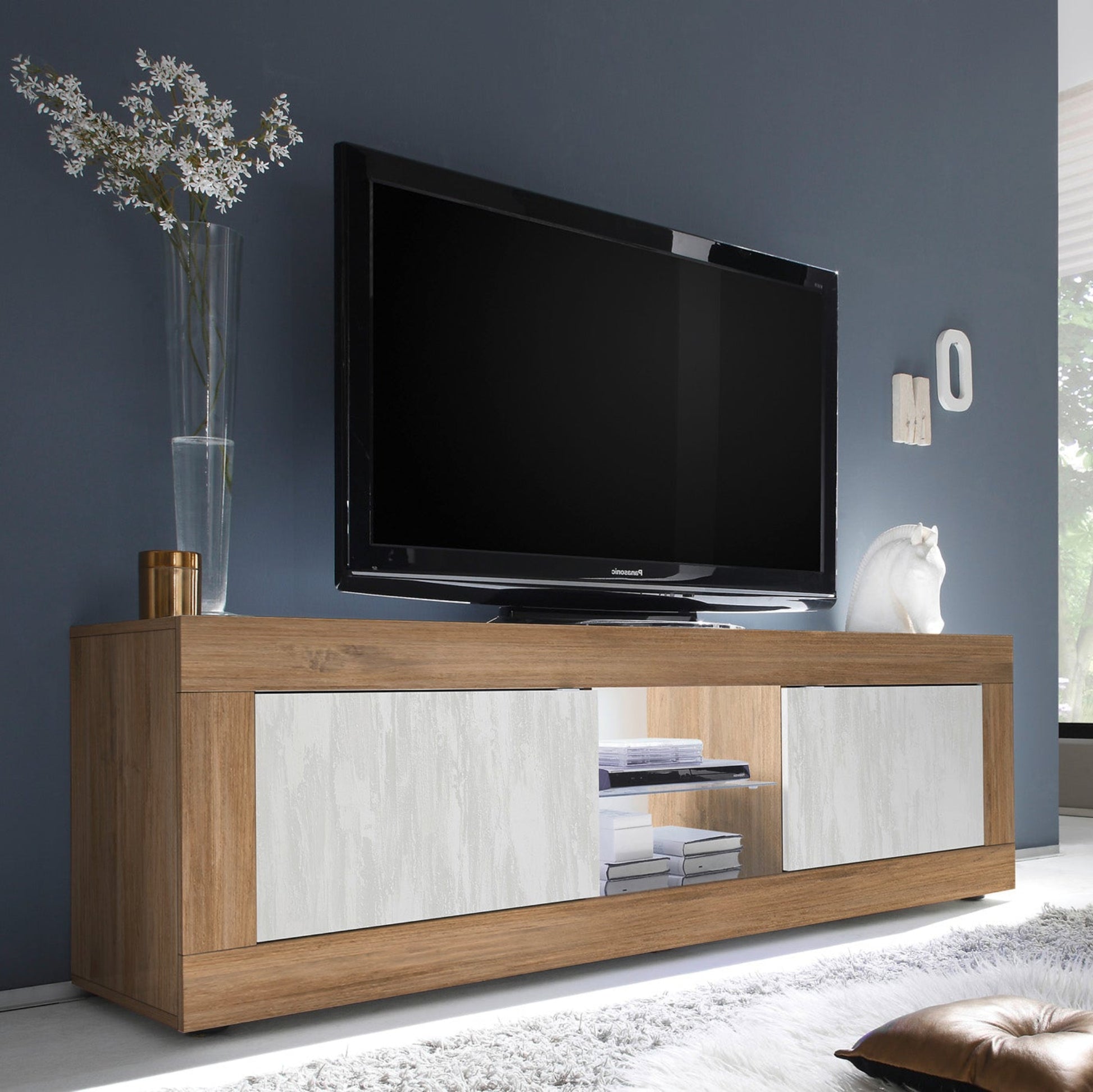 Modern living room with a wooden TV stand, flat-screen TV, and decorative items.