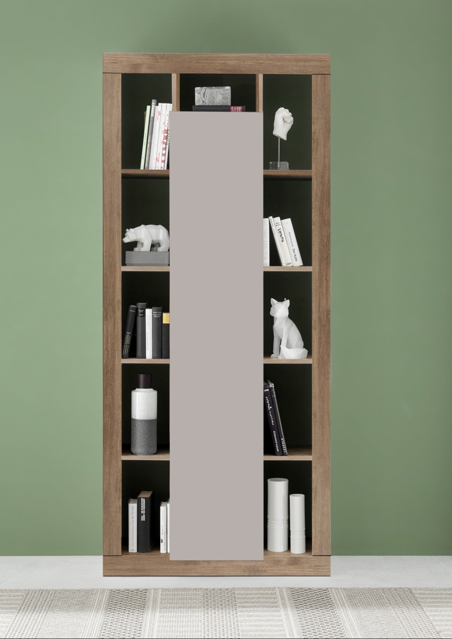 Tall wooden bookshelf with a gray door against a green wall