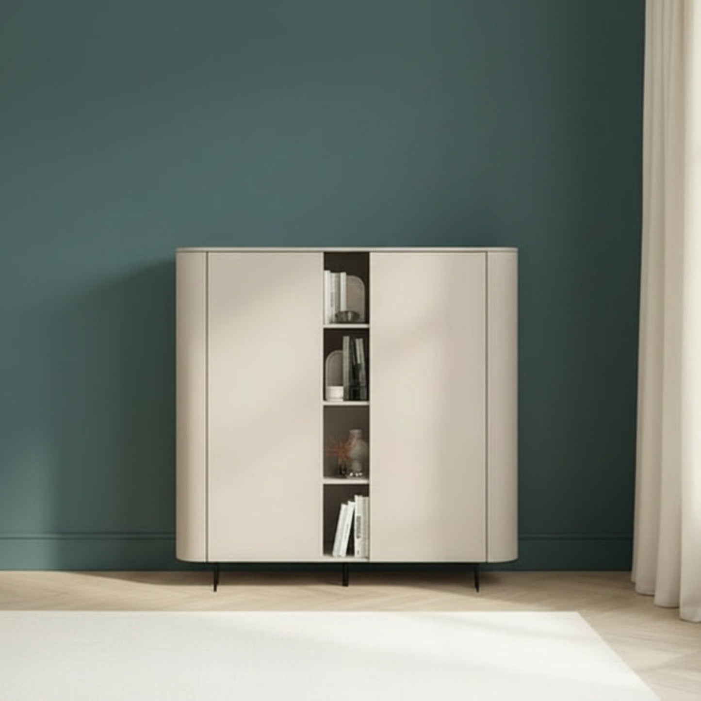 A modern sideboard cabinet with two cream-colored doors and an open center shelf, set against a dark teal wall in a minimalist room with a small wooden side table and a window with sheer curtains.