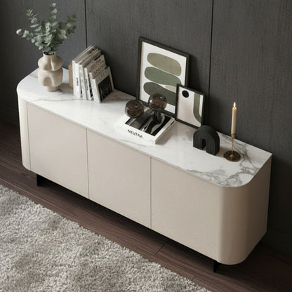 A modern cream-colored media console with a white and gray marble top, styled with books, a plant, and framed art in a dark room.