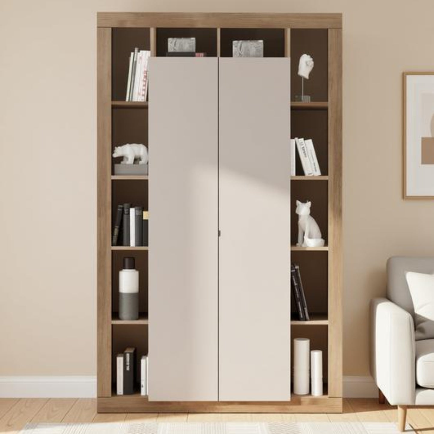 A tall built-in wardrobe or bookcase with two large light beige doors in the center and open shelving on both sides, shown in a styled room with books, decor, a rug, and part of a sofa.