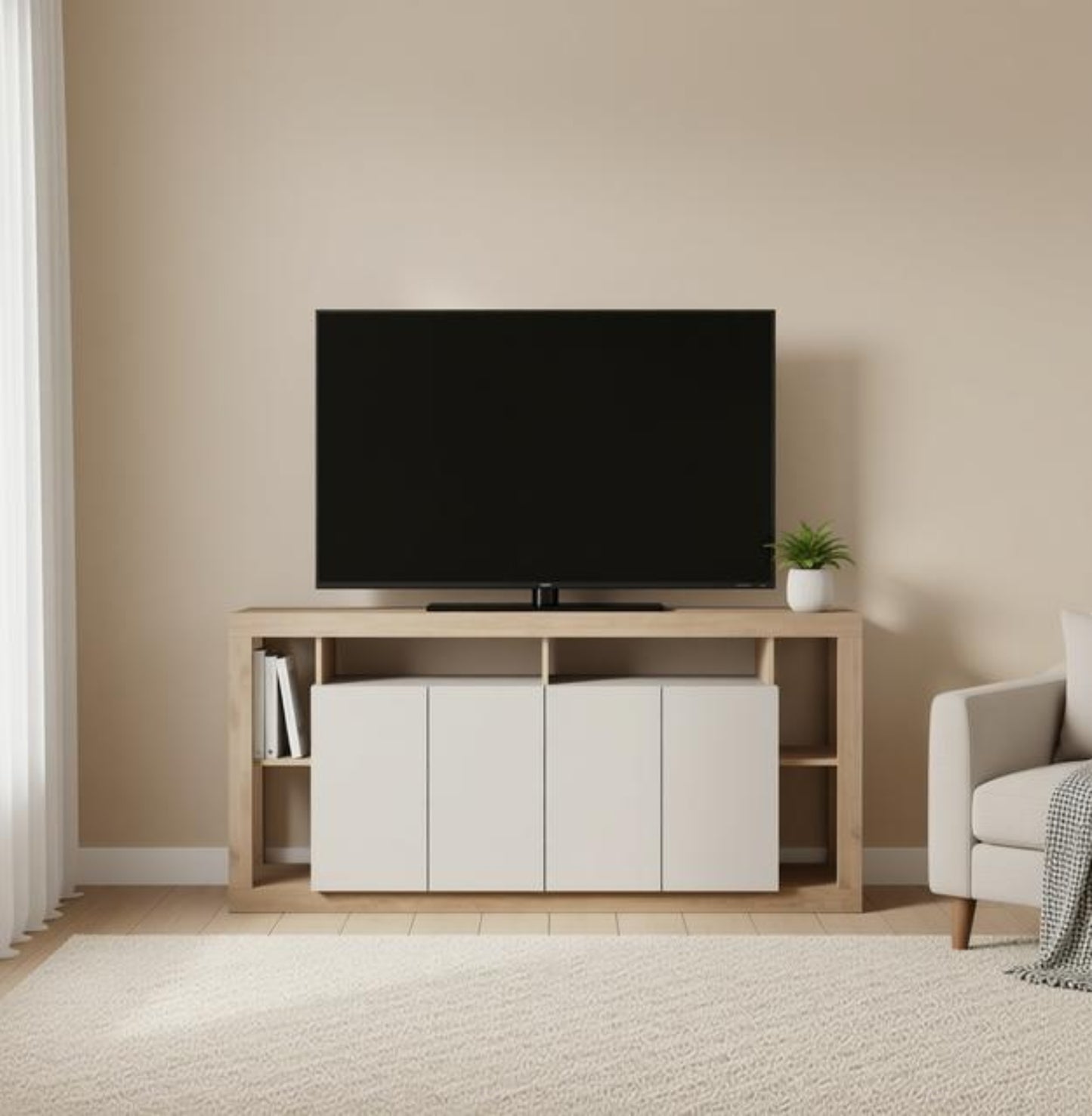 A light wood TV stand with white cabinet doors and open shelving, holding a black flat-screen TV in a minimalist living room with beige walls and a white armchair.