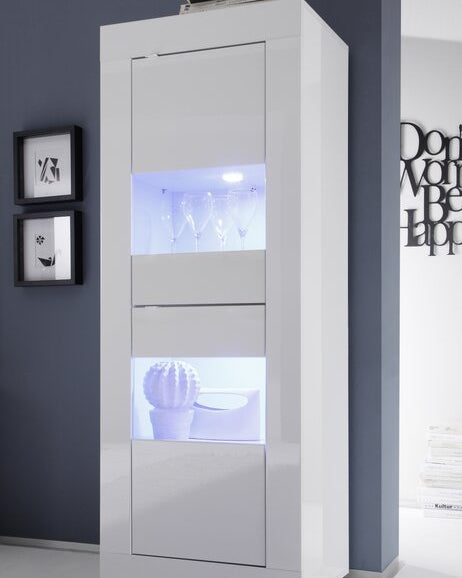 Tall white cabinet with glass doors displaying decorative items against a dark wall.
